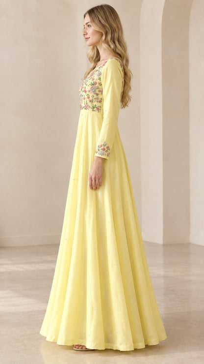 Side profile of women's flowing yellow embroidered evening gown