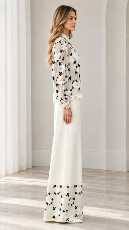 Side view of model in white floral lace matching blouse and wide-leg trousers
