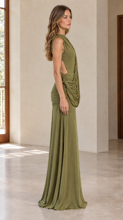 Side profile of woman in olive green draped evening gown showing back cutout