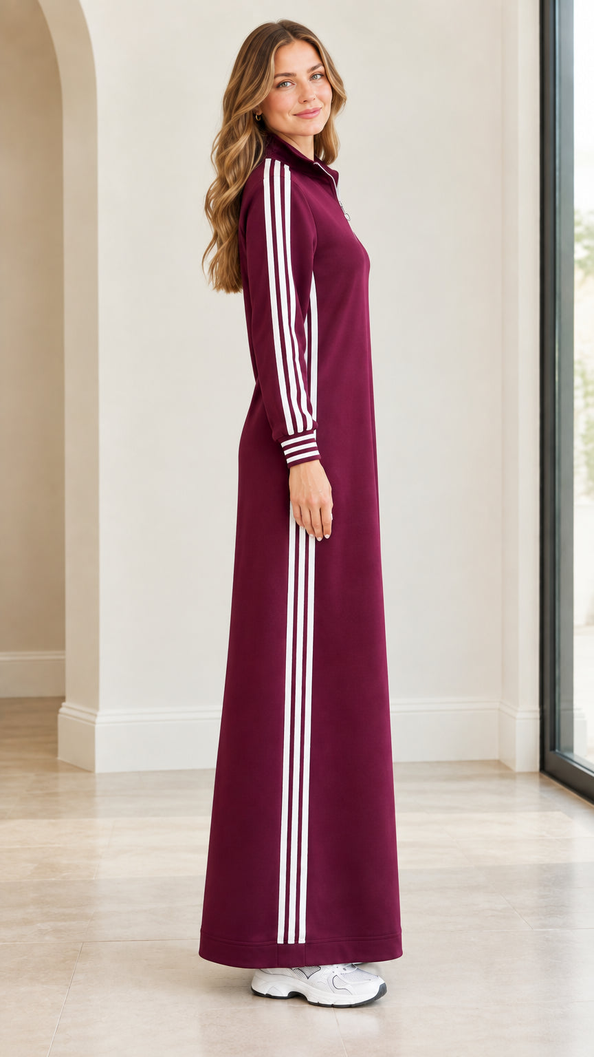 Side profile of burgundy long sleeve maxi dress with athletic white stripes
