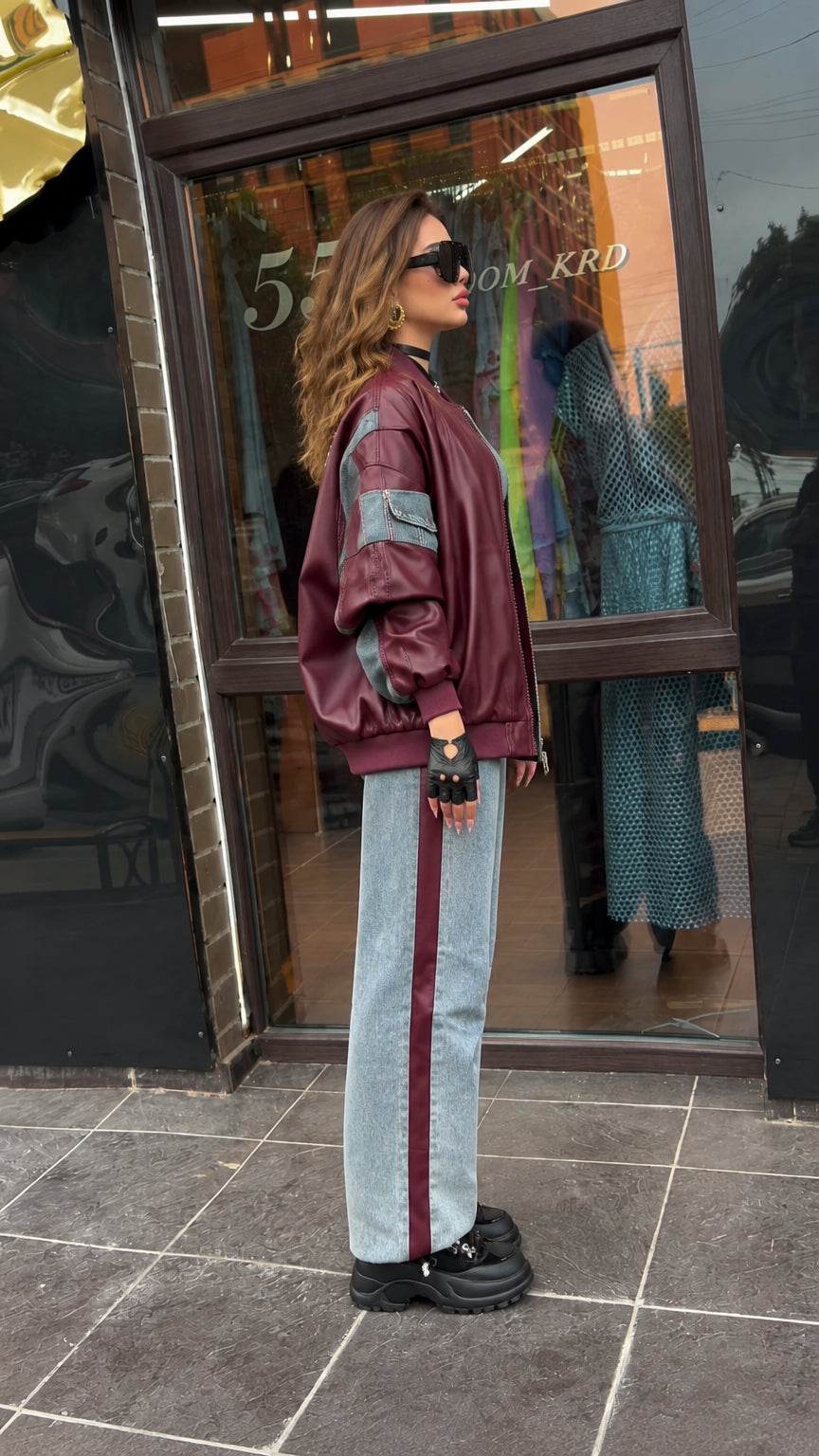 Side profile of model wearing relaxed burgundy faux leather jacket with sleeve pocket
