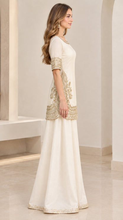 Side angle view of ivory embroidered kurti and sharara set