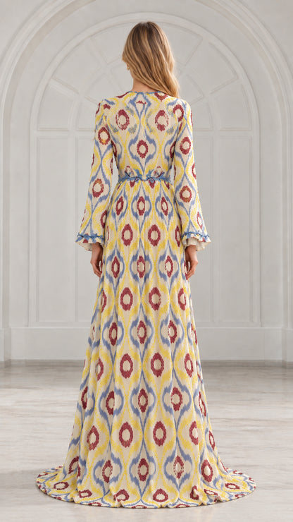 Back view of yellow ikat print pleated gown showing waistline and flowing hem