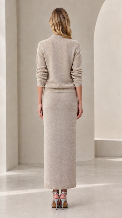 Back view of woman wearing beige knit long sleeve top and column maxi skirt
