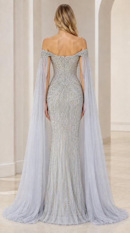Back view of model in slate blue beaded evening dress with floor-length tulle cape