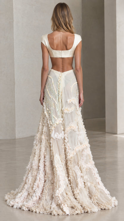 Back view of model wearing ivory cap sleeve crop top and sweeping ruffle skirt