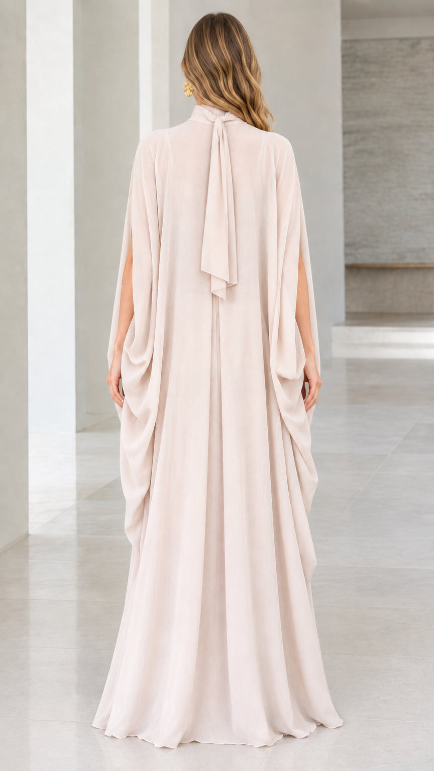 Back view of champagne cape gown with draped neck tie detail