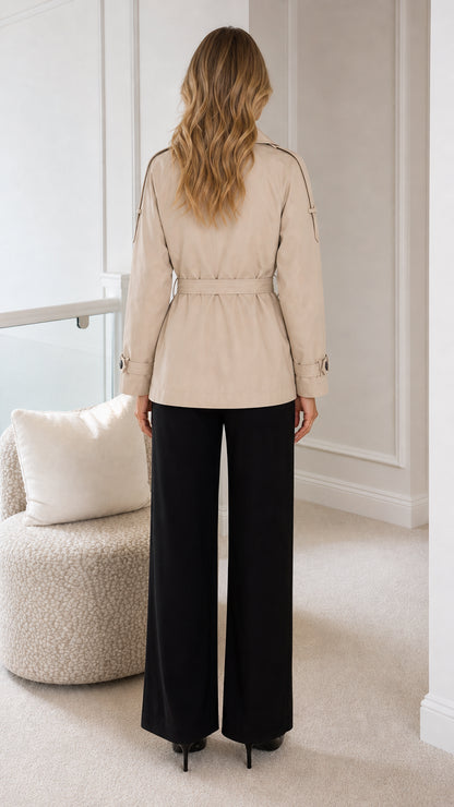 Back view of model wearing the beige hip-length belted trench coat
