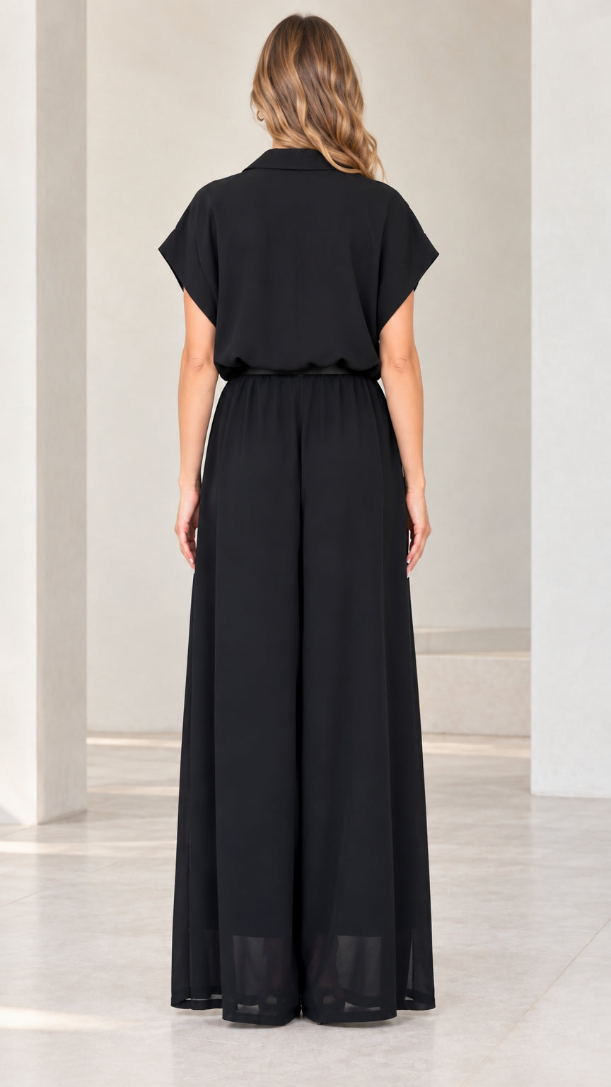 Back view of woman wearing flowing black wide-leg evening jumpsuit