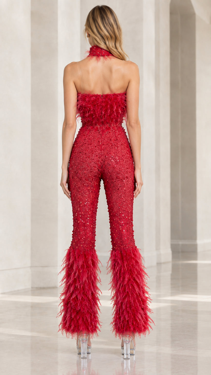 Back view of the red open-back sequin jumpsuit with halter neck and feather trims