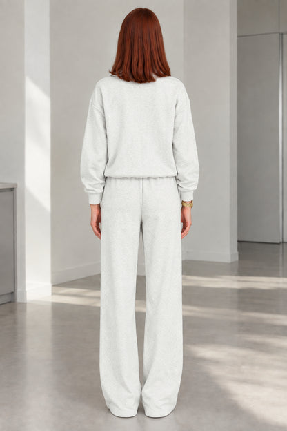 Back view of woman wearing Heather Grey zip jacket and wide-leg trousers