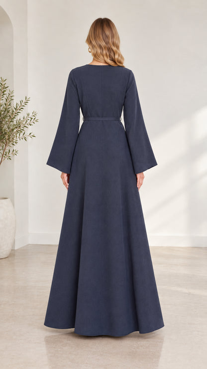 Back view of woman wearing navy blue long-sleeve maxi dress showing clean silhouette