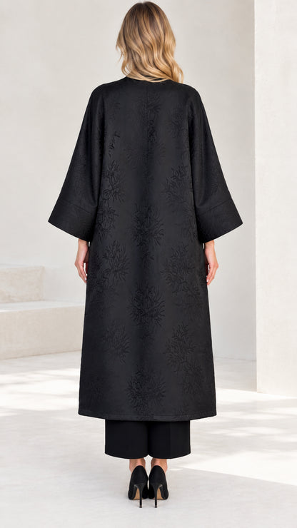 Back view of women's long black open front jacquard duster coat
