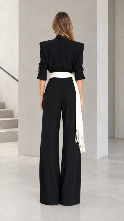 Back view of woman wearing Black power shoulder wide leg jumpsuit