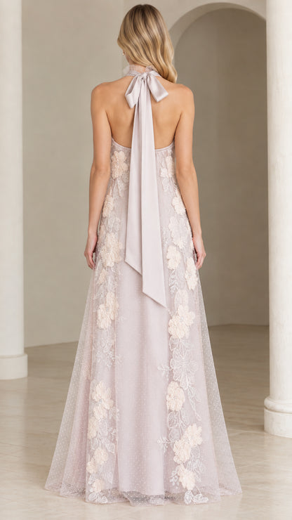 Back view of woman wearing open-back dusty lilac evening gown with trailing bow