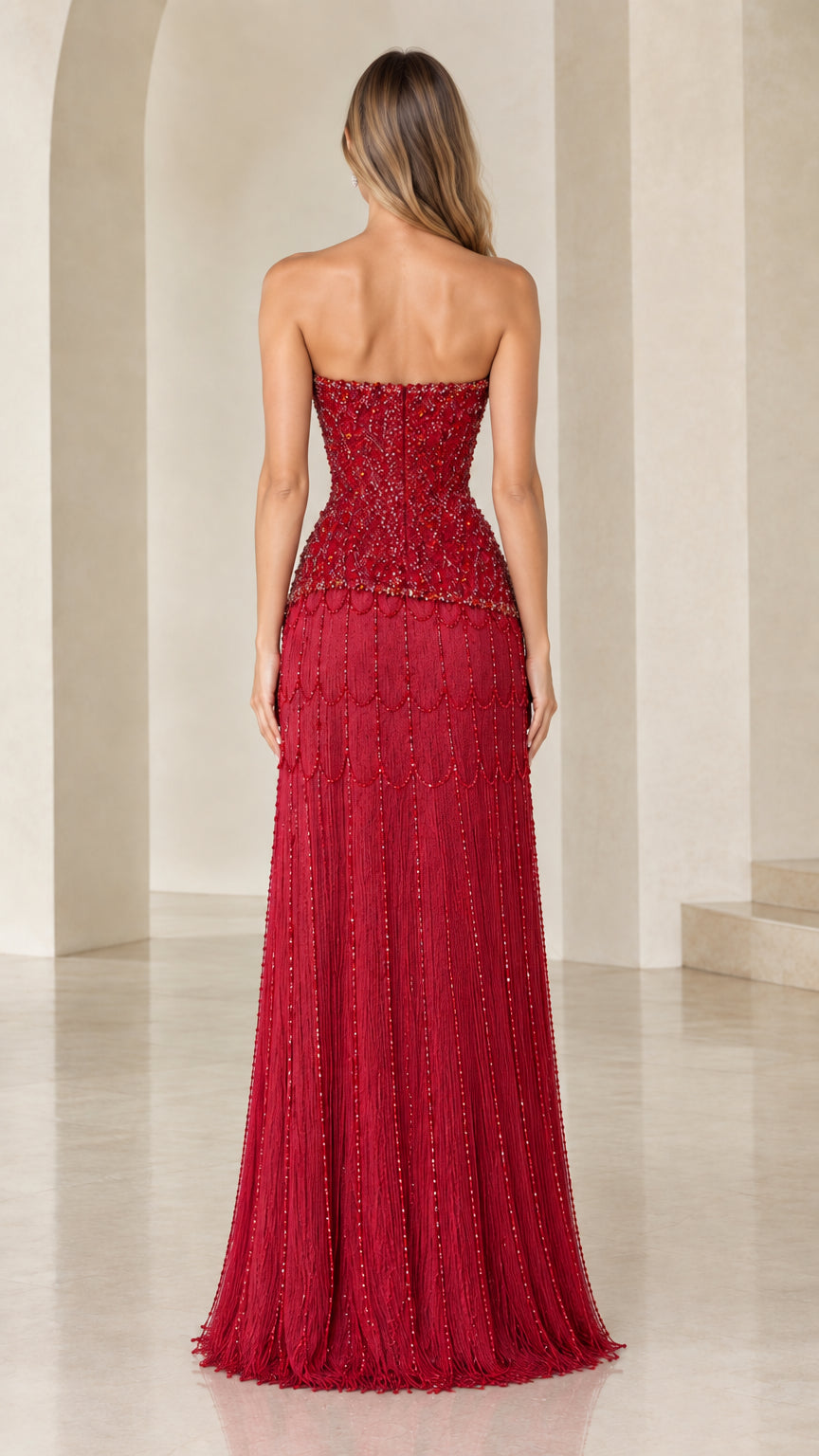 Back view of woman wearing strapless ruby red beaded formal gown