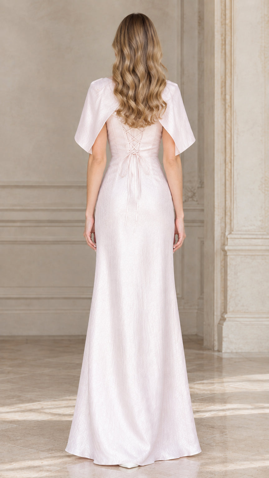 Back view of woman wearing blush pink maxi dress showing lace-up back detail