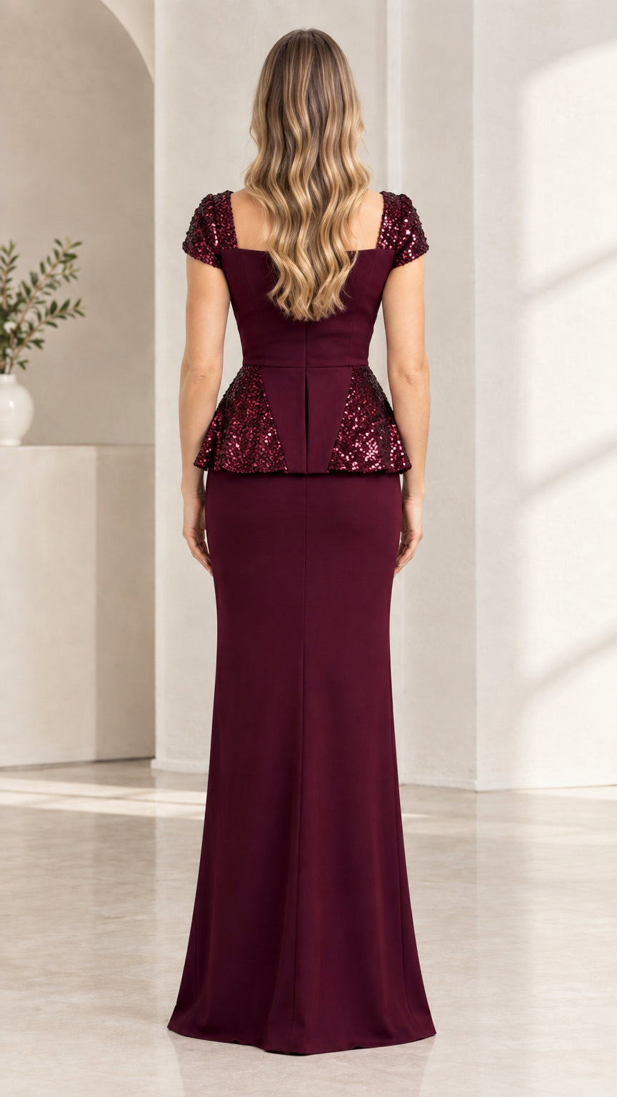 Back view of burgundy peplum evening gown showing sleek fitted silhouette