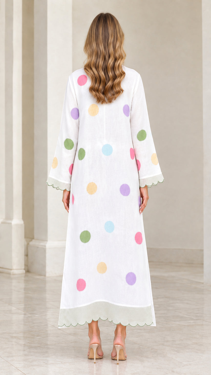 Back view of woman wearing white polka dot kaftan dress