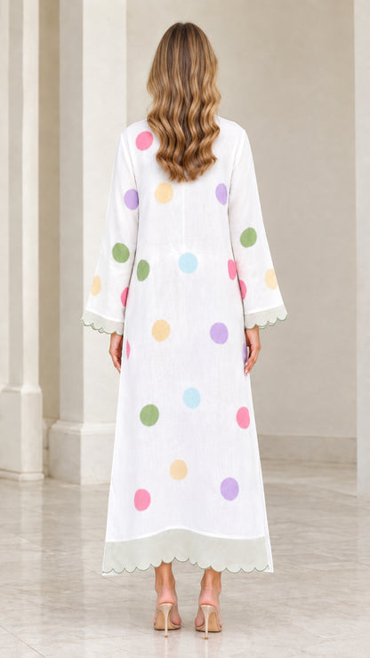 Back view of woman wearing white polka dot kaftan dress