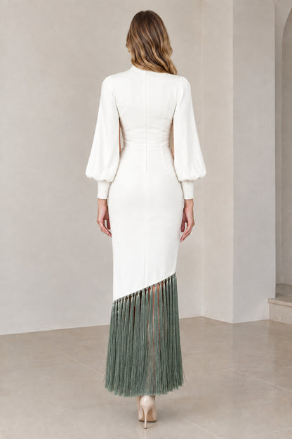 Back view of model wearing white cape sleeve dress with sage green fringe hem and back zipper