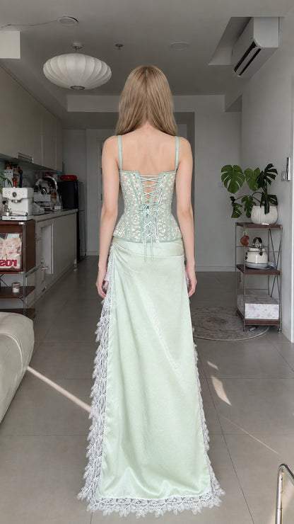 Back view of model showing lace-up corset back and flowing high-low skirt train