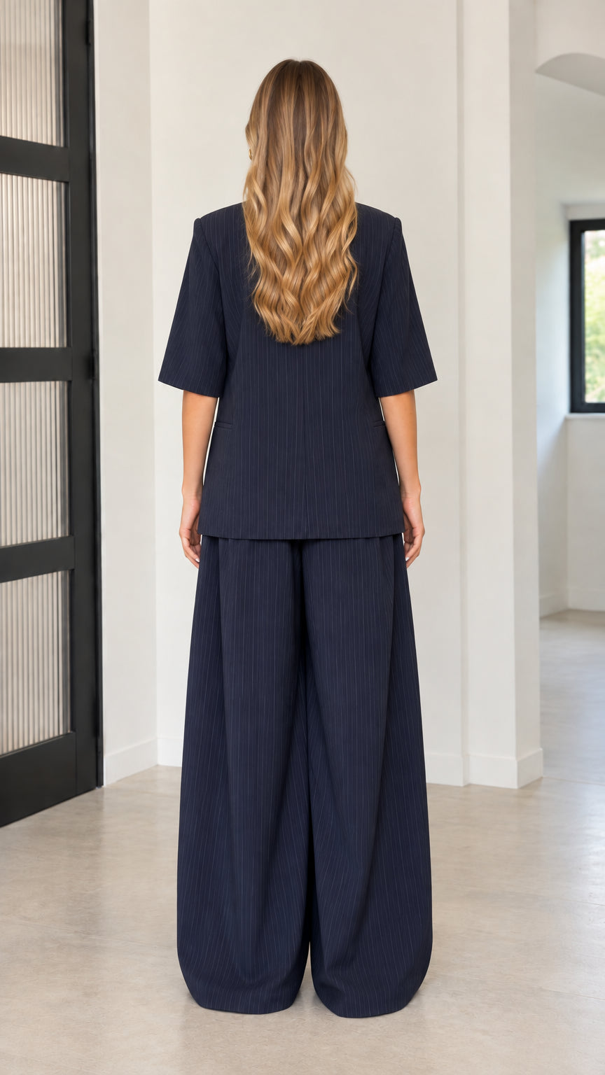 Back view of model wearing Navy Blue short sleeve blazer and wide-leg trousers