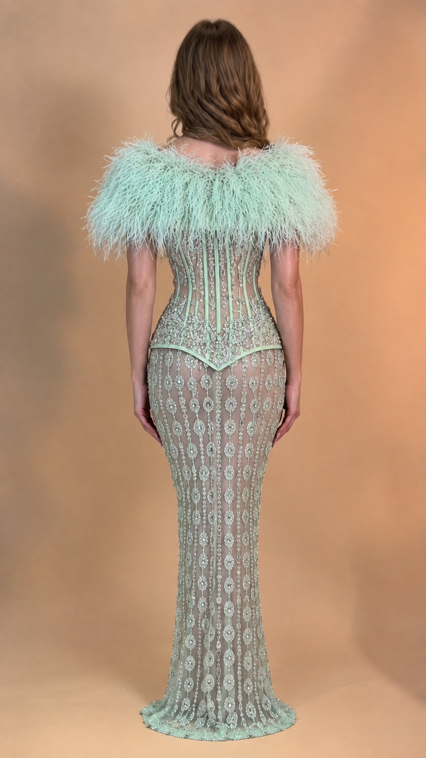 Back view of model wearing Mint Green sequin evening dress with feather capelet