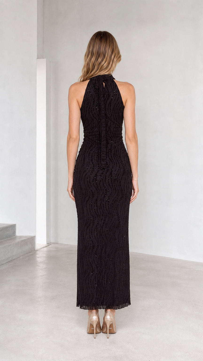 Back view of model wearing black high neck sleeveless evening maxi dress
