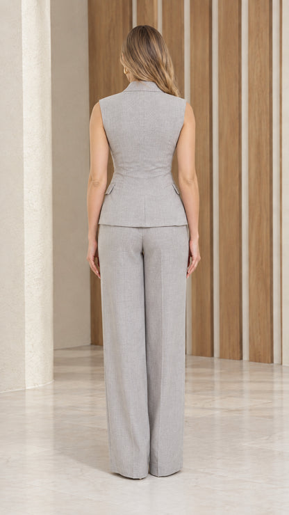 Back view of model wearing grey sleeveless waistcoat and straight wide-leg trousers