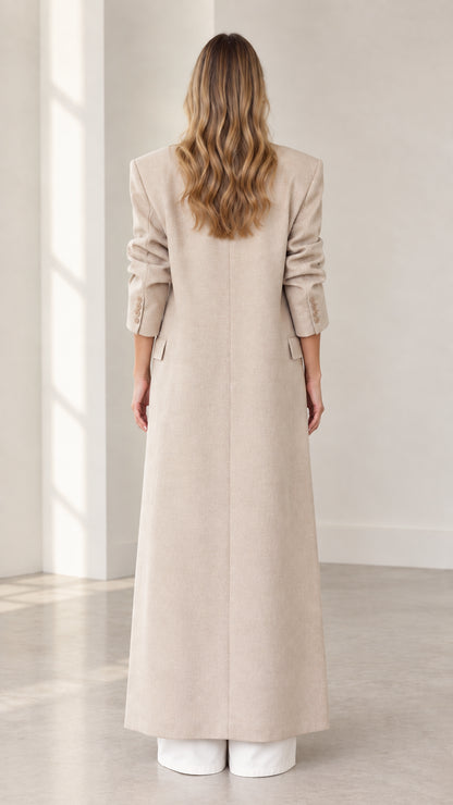 Back view of floor-length beige overcoat showing straight silhouette