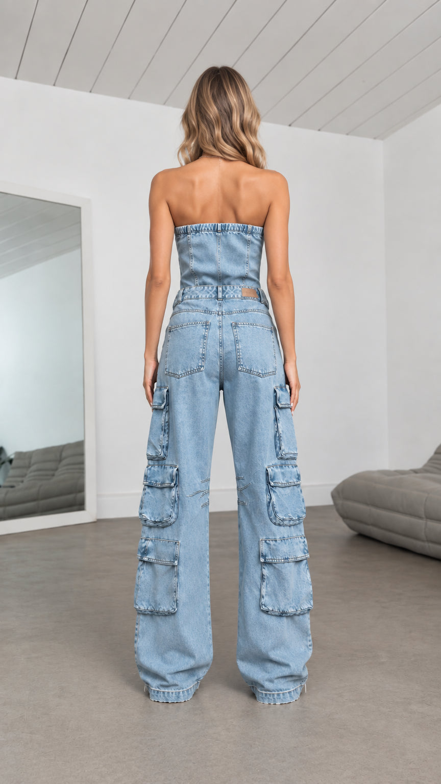 Back view of model in Light Blue strapless denim cargo jumpsuit