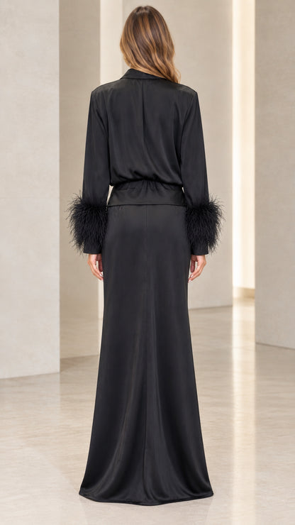 Back view of woman wearing long black satin dress with feather trimmed sleeves