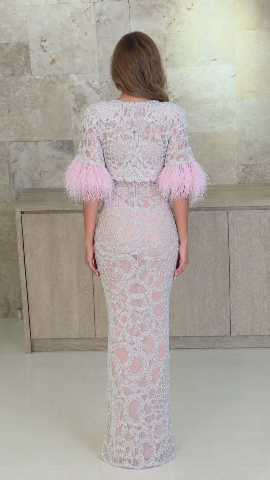 Back view of model showcasing full-length fitted embroidered gown