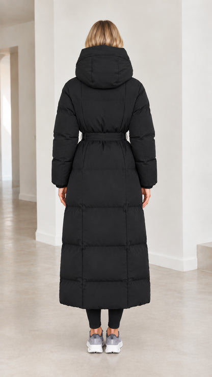Back view of model wearing black hooded maxi puffer coat cinched at waist