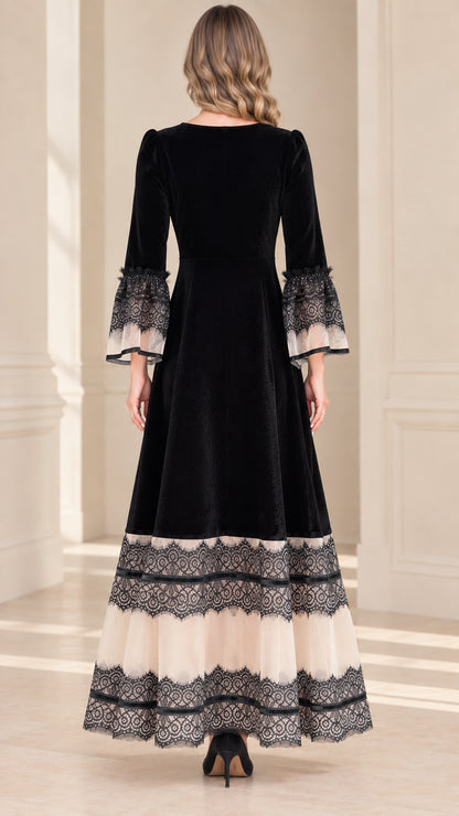 Back view of black velvet evening gown showing full-length silhouette and tiered lace bottom