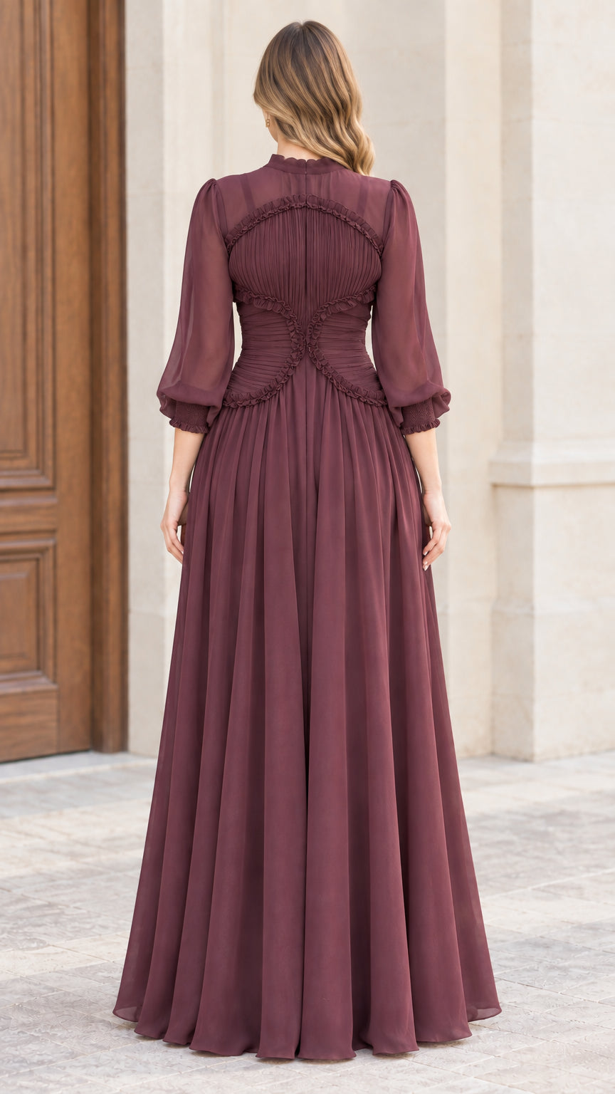 Back view of woman wearing burgundy pleated maxi dress showing contoured ruffle trim
