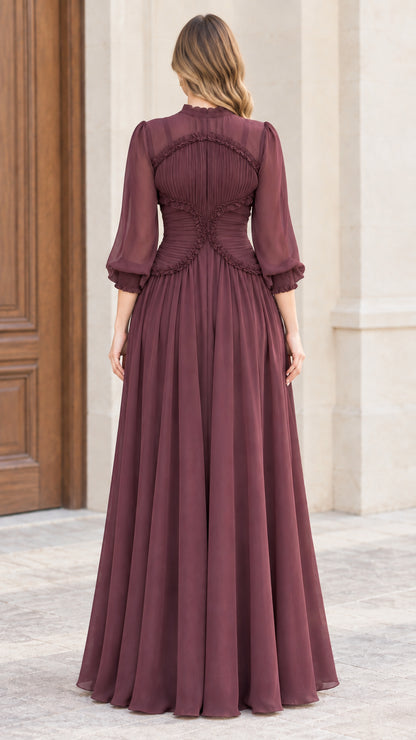 Back view of woman wearing burgundy pleated maxi dress showing contoured ruffle trim