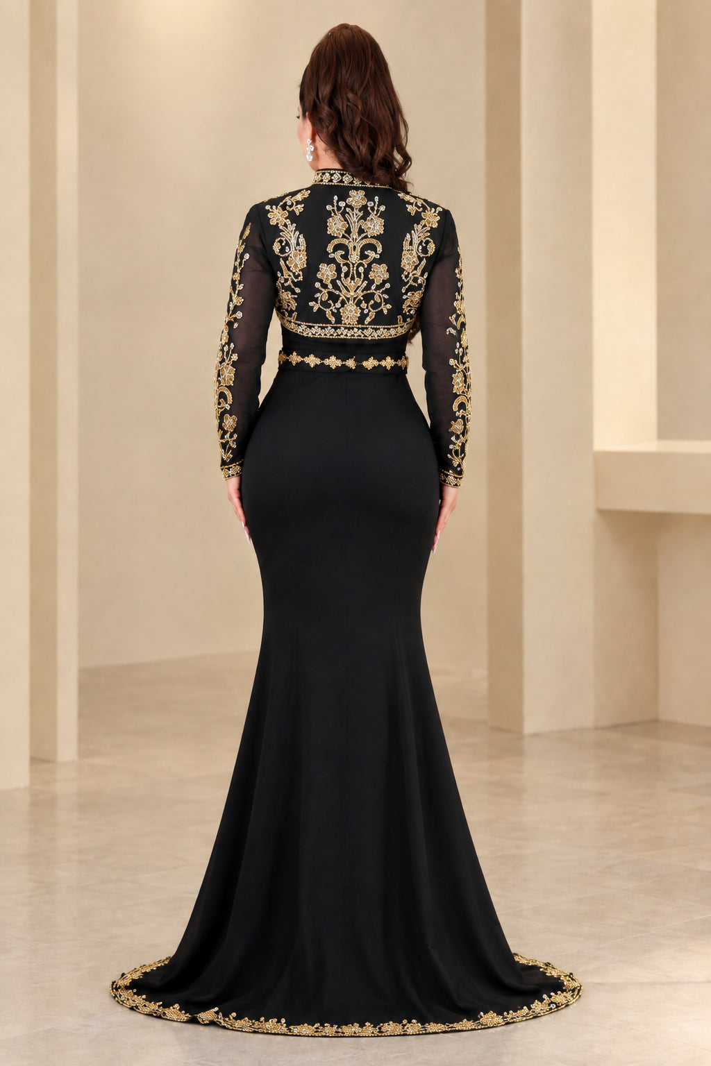 Back view of black formal gown showing detailed gold embroidery on jacket and trailing hem