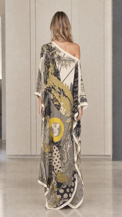 Back view of model in ivory one-shoulder printed flowing kaftan dress