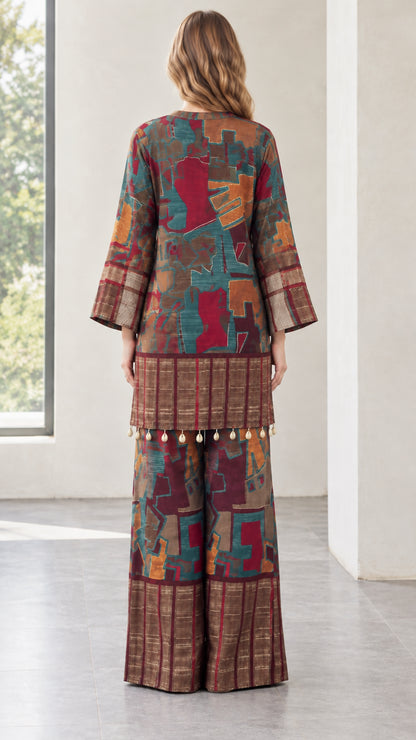 Back view of model in burgundy print longline tunic and wide-leg trousers