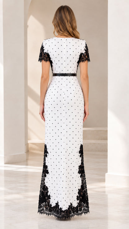 Model wearing white polka dot maxi dress with black lace trim - back view