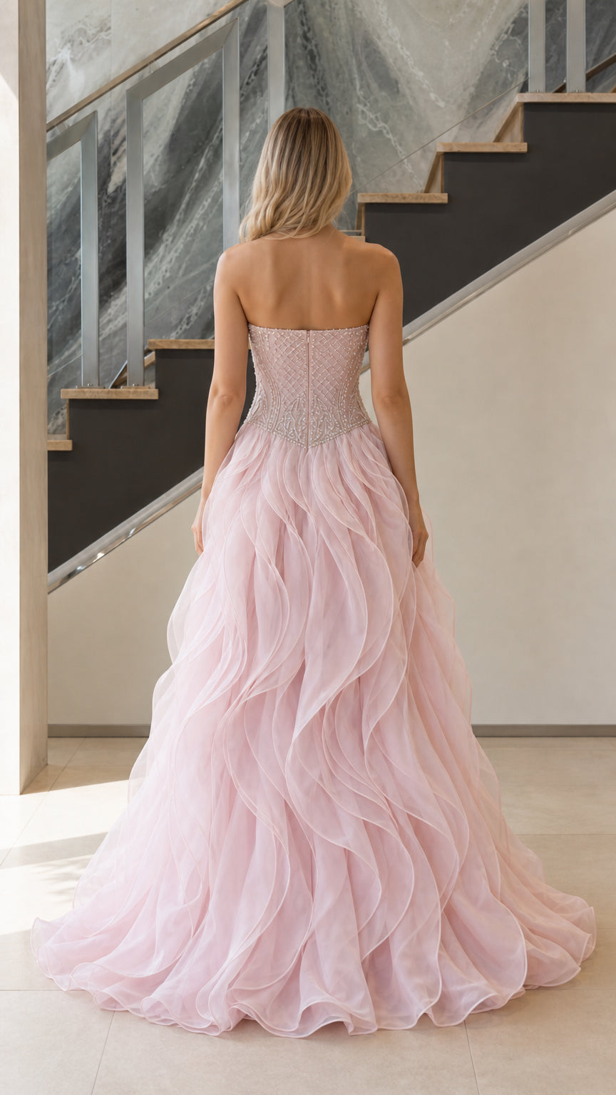 Back view of blush pink strapless organza ruffle ball gown