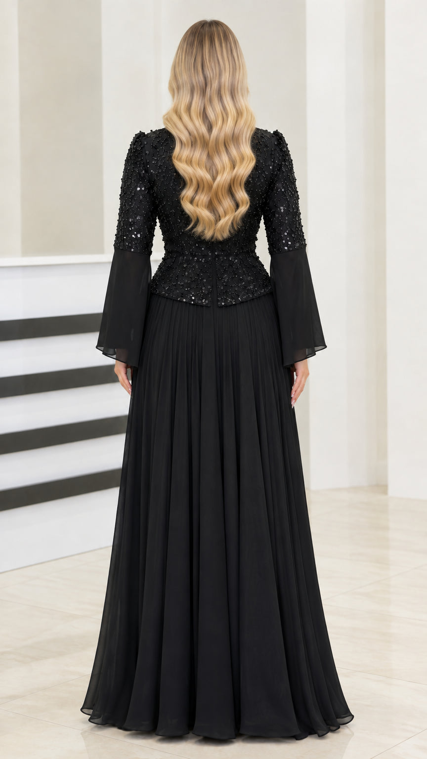 Back view of black long sleeve evening gown showing zip closure and flowy skirt