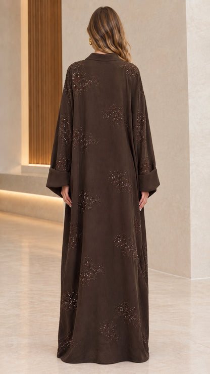 Back full-length view of woman wearing flowing brown collared abaya maxi dress