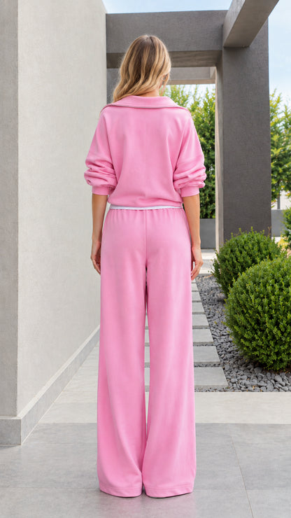 Back view of model wearing relaxed pink two-piece tracksuit set