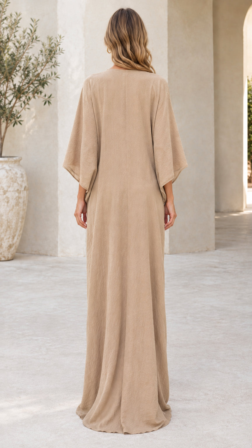 Back view of woman wearing beige loose-fit kaftan maxi dress