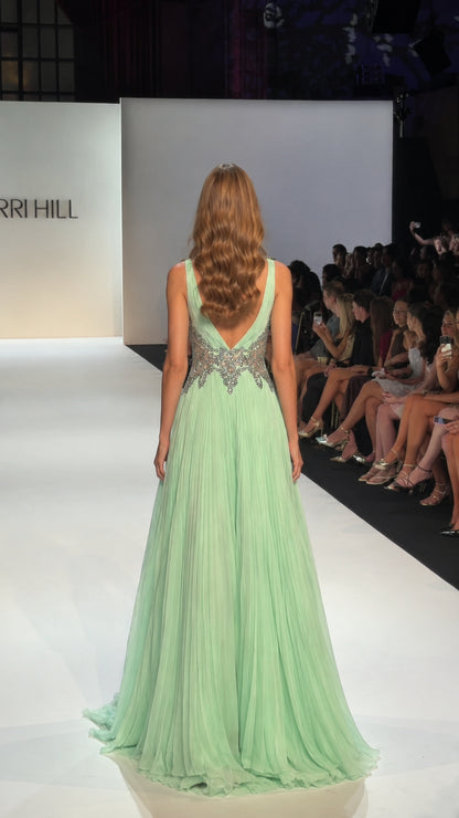 Mint green floor-length evening gown showing the pleated back and V-shaped back opening