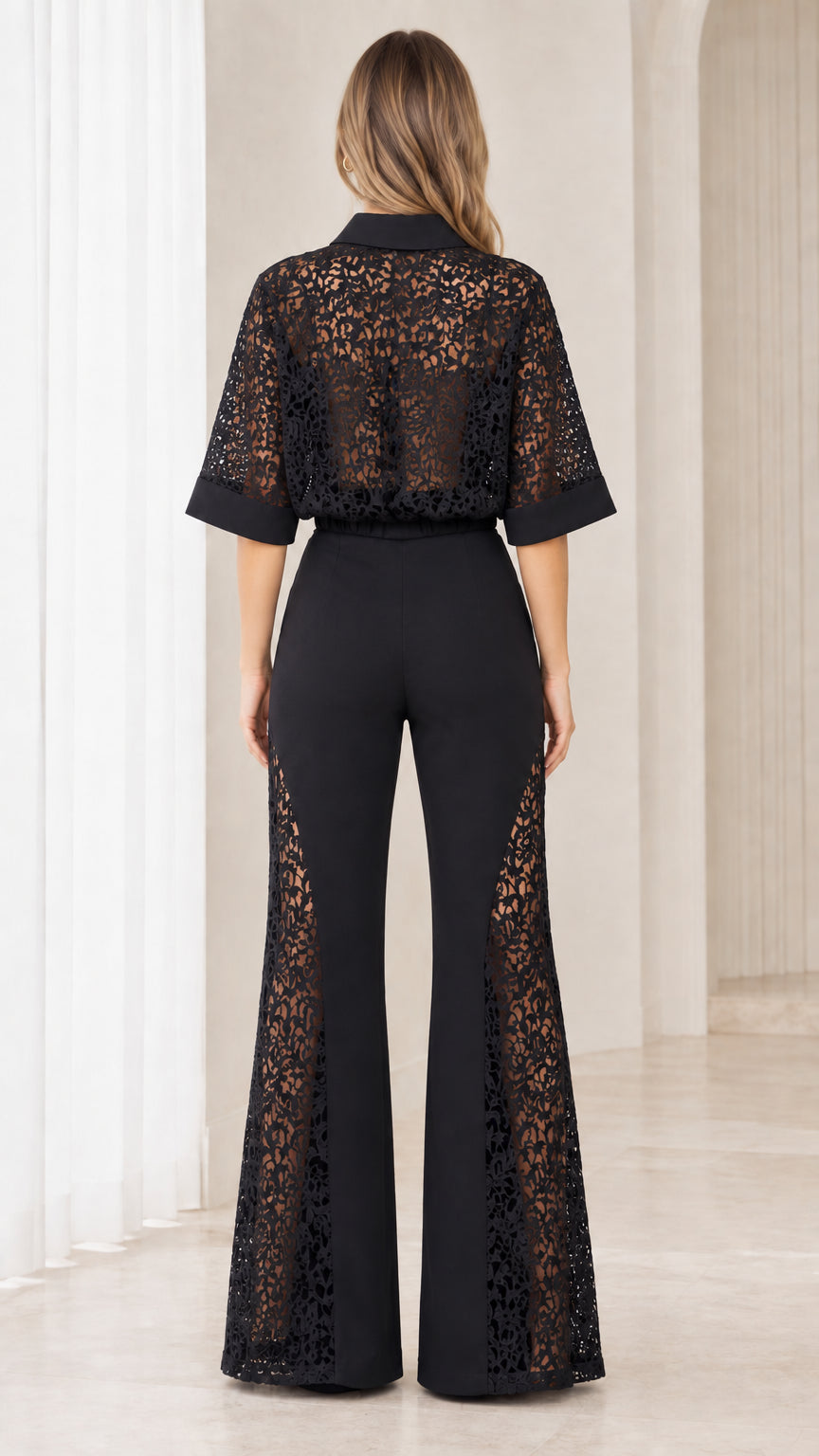 Back view of model highlighting sheer lace back on black jumpsuit