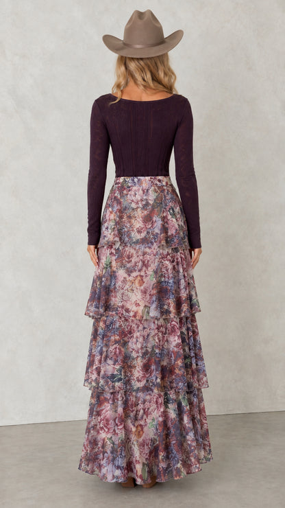 Back view of woman showing the tiered ruffle layers of floral maxi skirt